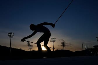 Ein Biathlet läuft auf einer Strecke.