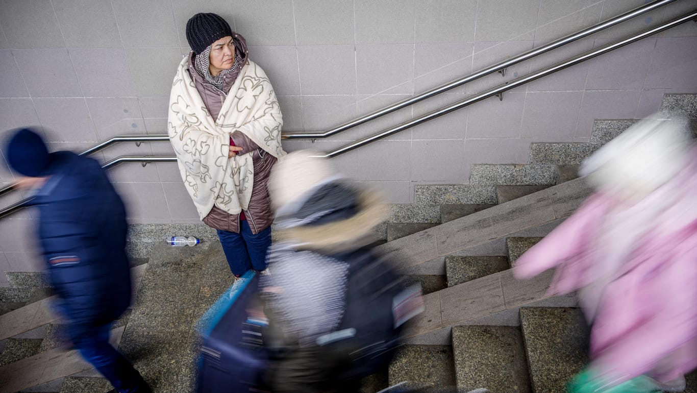 Polen: In eine Decke gehüllt steht eine geflüchtete Frau im Treppenaufgang zu den Gleisen im Bahnhof in der Nähe des ukrainsch-polnischen Grenzübergangs. Auch die Stadt Köln erwartet 180 Geflüchtete.