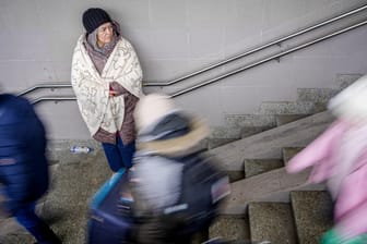 Polen: In eine Decke gehüllt steht eine geflüchtete Frau im Treppenaufgang zu den Gleisen im Bahnhof in der Nähe des ukrainsch-polnischen Grenzübergangs. Auch die Stadt Köln erwartet 180 Geflüchtete.