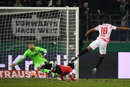 Christopher Nkunku (r) trifft zur 1:0-Führung gegen Hannovers Torwart Ron-Robert Zieler.