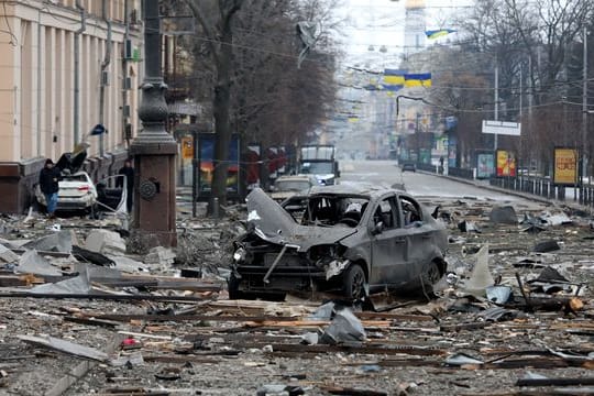 Ein ausgebranntes Autos in der Nähe des durch Angriffe zerstörten Gebäudes der regionalen Verwaltung von Charkiw.