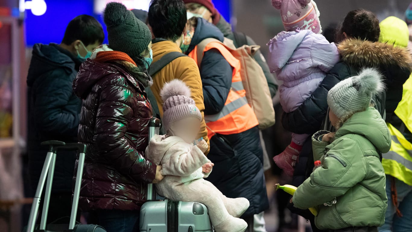 Geflüchtete aus dem ukrainischen Kriegsgebiet warten im Hauptbahnhof Berlin: Freiwillige helfen ihnen mit erster Verpflegung aus.