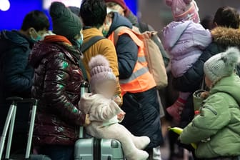 Geflüchtete aus dem ukrainischen Kriegsgebiet warten im Hauptbahnhof Berlin: Freiwillige helfen ihnen mit erster Verpflegung aus.