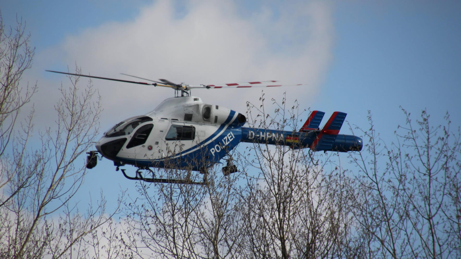 Ein Polizeihubschrauber über einem Waldstück (Symbolbild): Seit Anfang Februar gilt die 32-Jährige als vermisst.