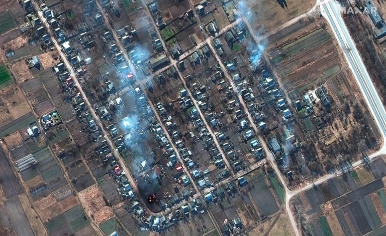 Rivnopillya, Ukraine: Das Satellitenbild zeigt eine Nahaufnahme brennender Häuser und Einschlagskrater auf einem Feld.