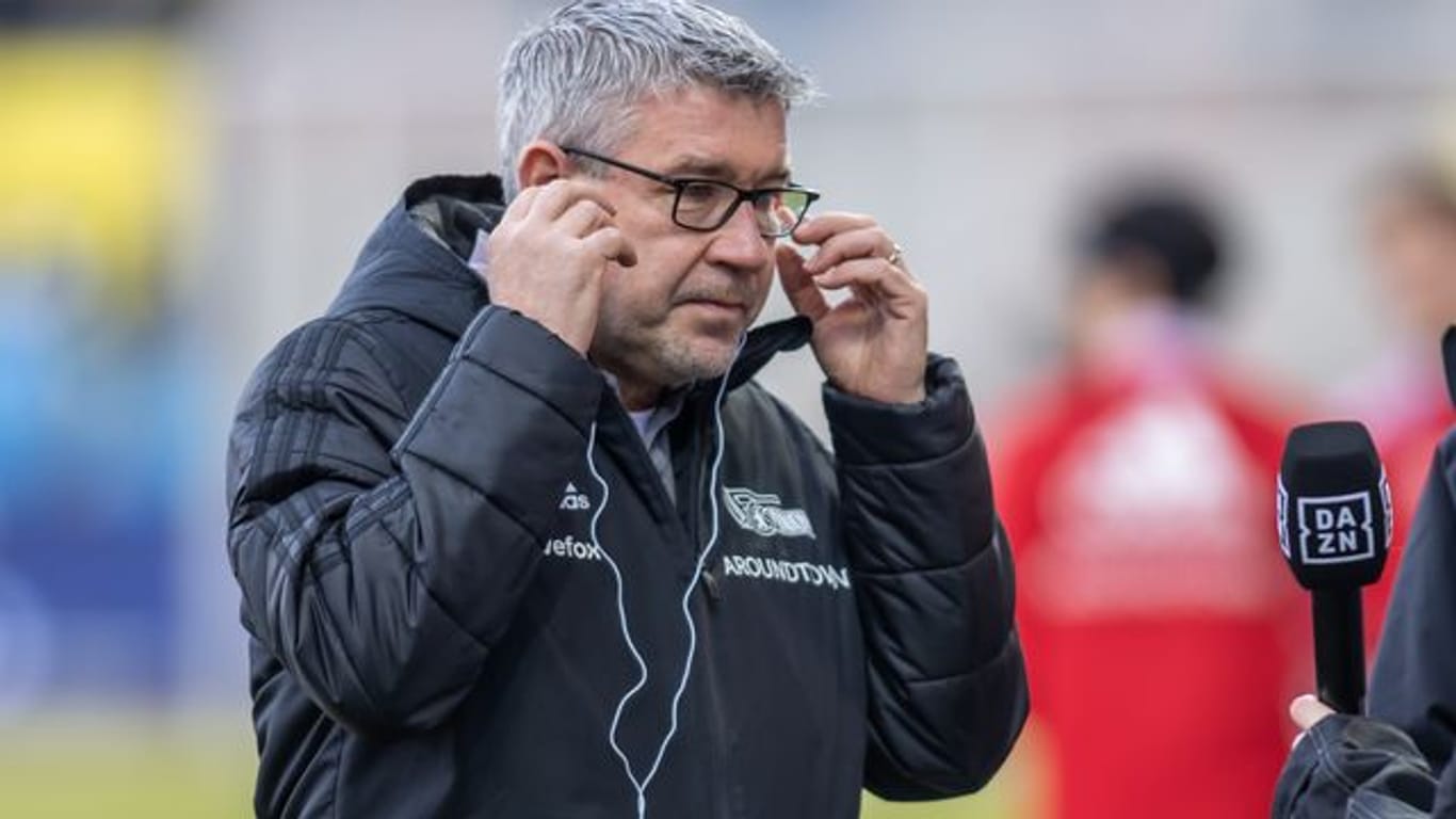 Union-Trainer Urs Fischer richtet seine Kopfhörer im Interview vor Spielbeginn.