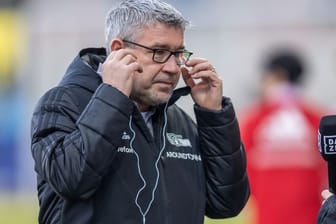 Union-Trainer Urs Fischer richtet seine Kopfhörer im Interview vor Spielbeginn.
