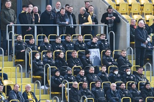 Spieler der SG Dynamo Dresden und Gäste sitzen während der öffentlichen Gedenkfeier zu Ehren von Hans-Jürgen "Dixie" Dörner im Rudolf-Harbig-Stadion.