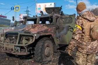Charkiw: Ein ukrainischer Soldat inspiziert ein beschädigtes Militärfahrzeug.