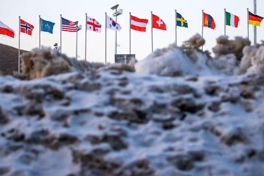 Die Fahnen der Teilnehmerländer an den Paralympics wehen im Biathlon-Stadion.