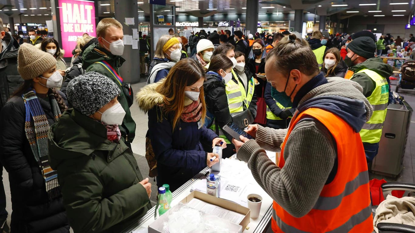 Ukrainische Flüchtlinge werden am Hauptbahnhof in Berlin von ehrenamtlichen Helfern empfangen.