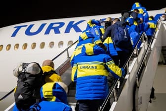 Para-Athleten und Delegationsmitglieder aus der Ukraine steigen am Flughafen von Istanbul in das Flugzeug nach Peking.