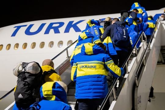 Para-Athleten und Delegationsmitglieder aus der Ukraine steigen am Flughafen von Istanbul in das Flugzeug nach Peking.