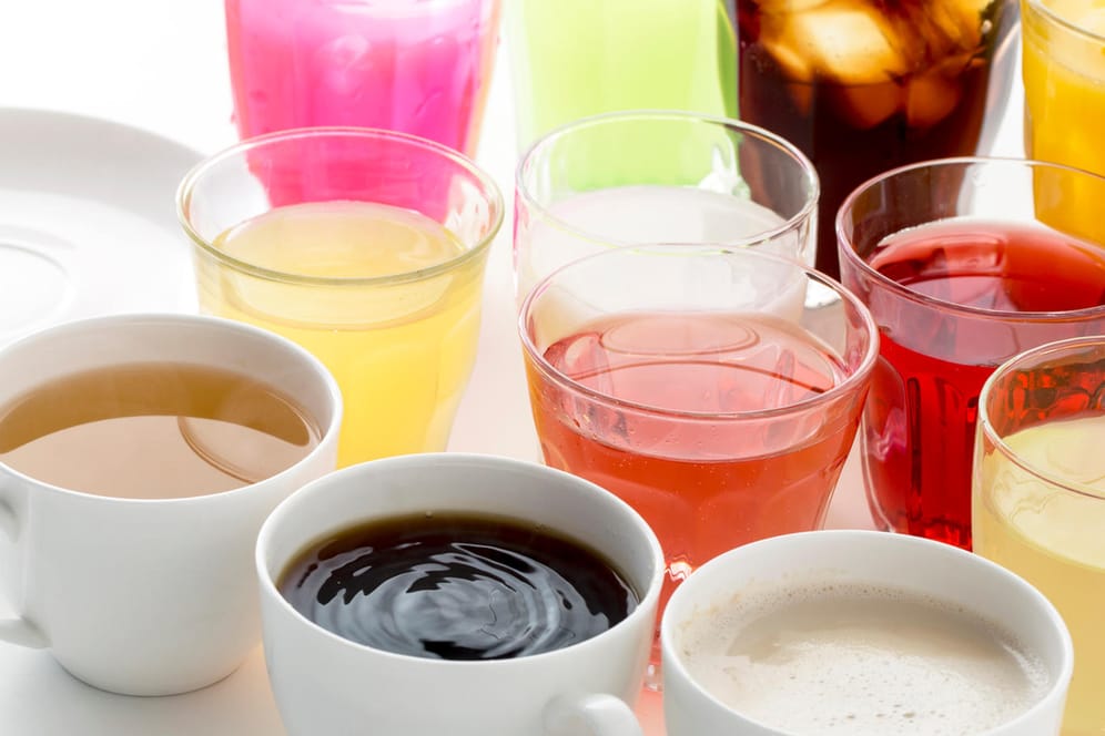 Auswahl an Heißgetränken und Softdrinks. Koffeinhaltige Getränke wie Tee und Kaffee, Alkohol und Fruchtsäfte können den Harndrang verstärken.