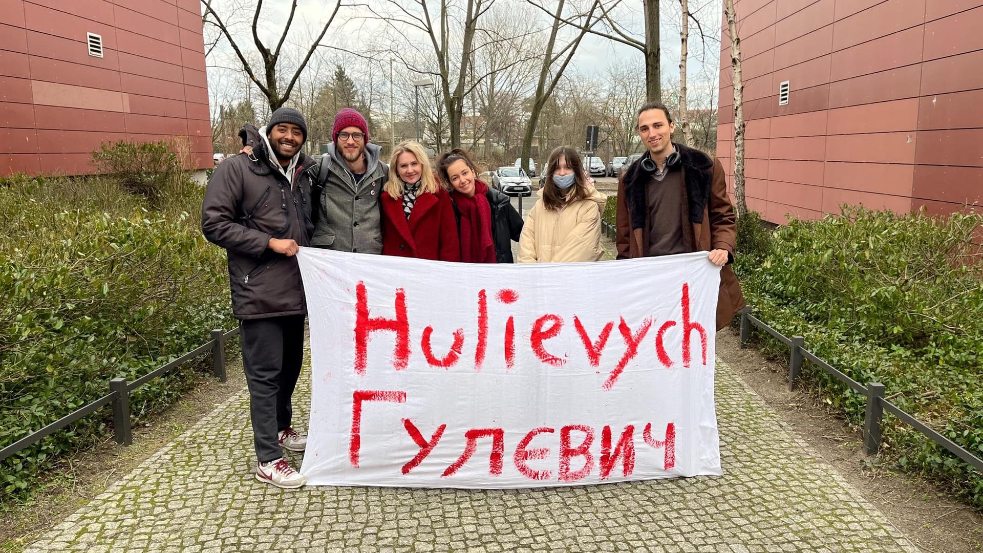 Daniel Heinz (rechts) mit der Familie, die er bei sich aufgenommen hat, zwei Helfern (links) und einer ukrainischen Freundin (Mitte): Auf dem Banner steht der Name der Familie in lateinischen und kyrillischen Schriftzeichen.