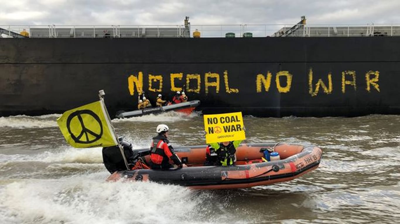 Greenpeace-Aktivisten vor dem Frachter "Gran T": Sie sind gegen die Abhängigkeit von fossilen Rohstoffen.