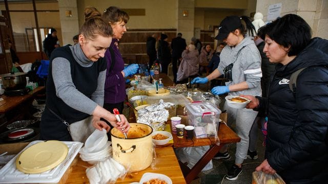 Menschen, die kurz zuvor evakuiert wurden, erhalten am Bahnhof von Uzhhorod in der Westukraine eine warme Mahlzeit.