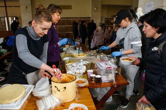 Menschen, die kurz zuvor evakuiert wurden, erhalten am Bahnhof von Uzhhorod in der Westukraine eine warme Mahlzeit.