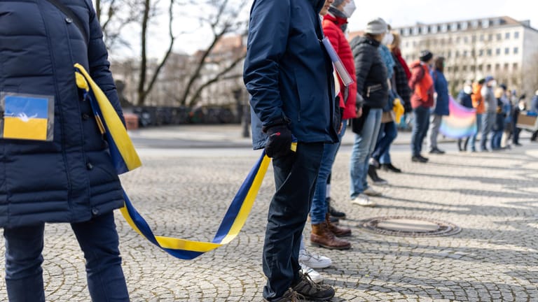 Teilnehmer einer Demonstration zum Ukraine-Konflikt bilden eine Menschenkette.