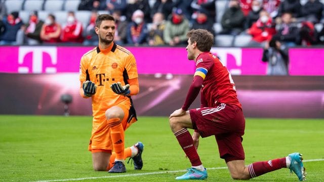 Thomas Müller (r) und Bayern-Torwart Sven Ulreich knien nach dem Eigentor von Müller auf dem Rasen.