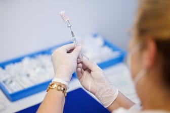 Eine Krankenschwester zieht im Impfzentrum Freising den Impfstoff Nuvaxovid auf eine Spritze auf.
