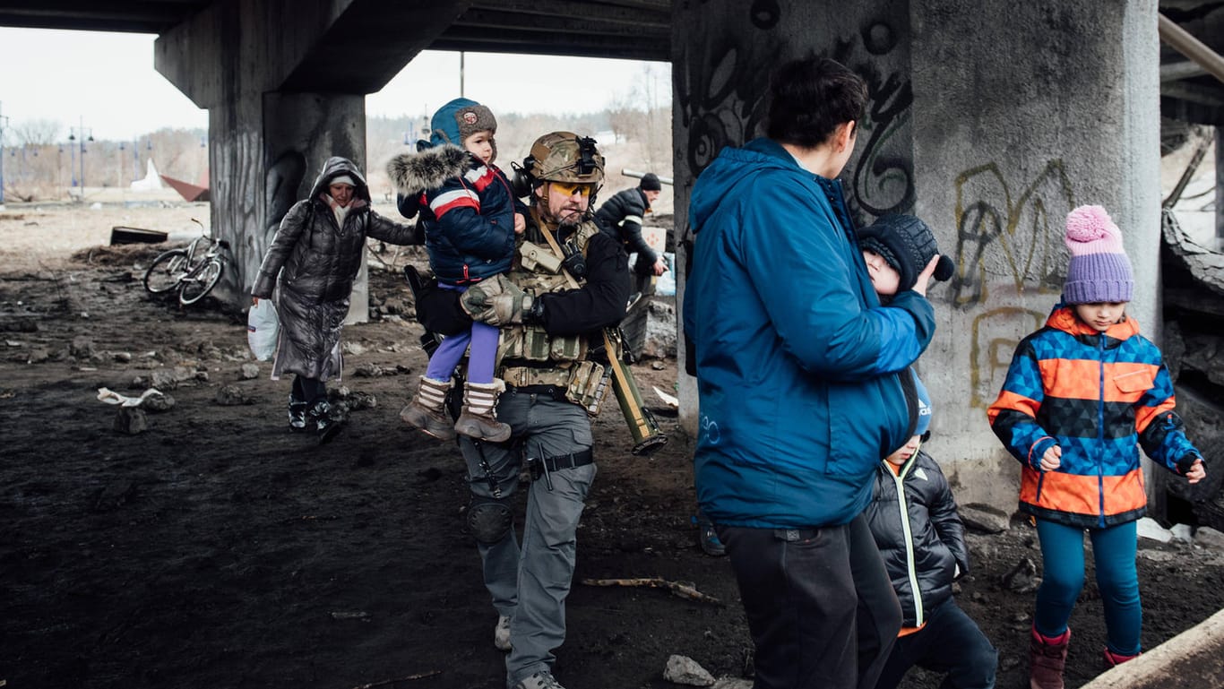 Ein ukrainischer Soldat trägt ein Kind: Millionen von Menschen fliehen aus der Ukraine.