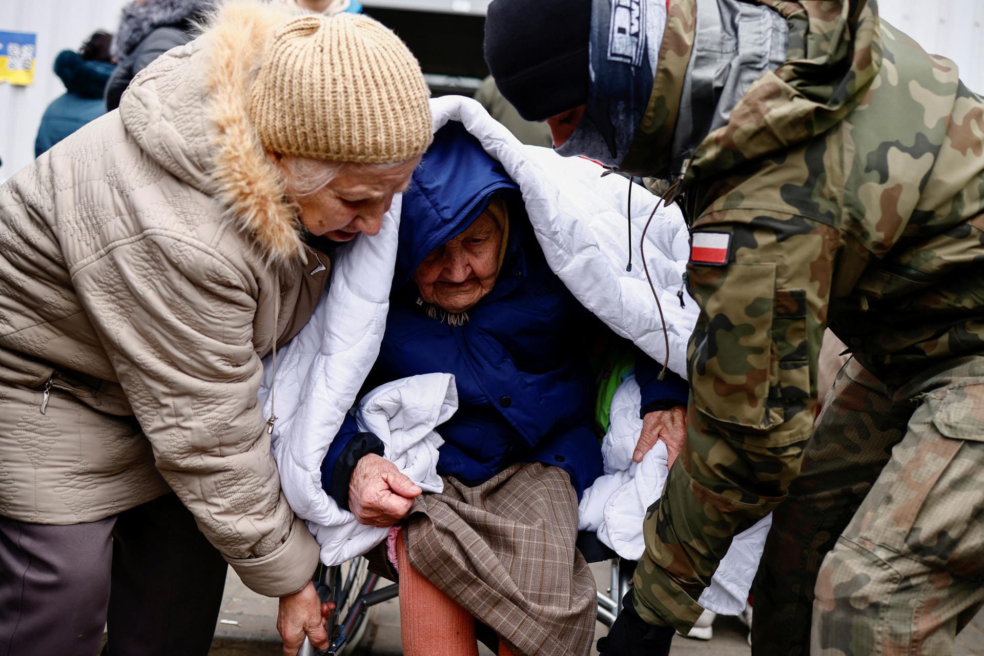 In Polen werden ukrainische Flüchtlinge von einem Soldaten versorgt.