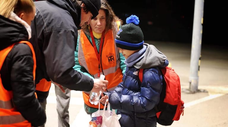 Helfer versorgen den kleinen Jungen bei der Ankunft: Der Elfjährige kam ganz alleine über die Grenze.