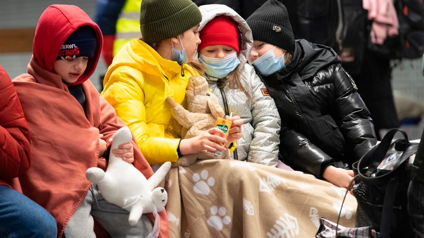 In Decken gehüllt sitzen diese Kinder aus dem ukrainischen Kriegsgebiet auf einer Bank im Berliner Hauptbahnhof: Auch an diesem Morgen sind bereits zahlreiche Flüchtlinge aus dem Kriegsgebiet in Berlin angekommen.