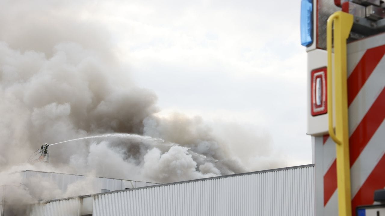 Feuerwehrleute löschen den Brand in einem Möbelhaus. Feuerwehrleute löschen den Brand in einem Möbelhaus.