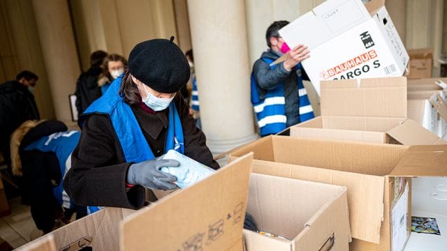 Freiwilige Helfer packen am Berliner Humboldt Forum Hilfsgüter in Kisten. Freiwilige Helfer packen am Berliner Humboldt Forum Hilfsgüter in Kisten.