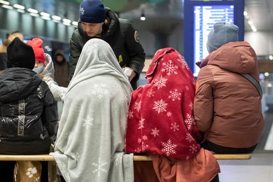 In Decken gehüllt sitzen diese Kinder aus dem ukrainischen Kriegsgebiet im Berliner Hauptbahnhof.