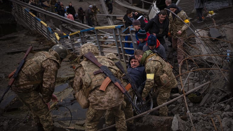 Irpin: Ukrainische Soldaten evakuieren Zivilisten, während der Ort von russischer Artillerie beschossen wird.