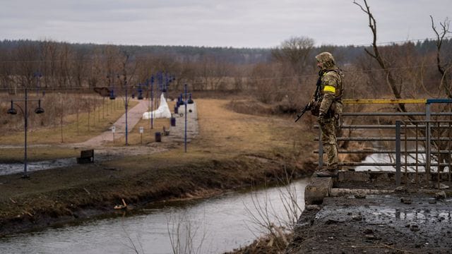 Ein ukrainischer Soldat in der Nähe einer zerstörten Brücke am Fluss Irpin. Ein ukrainischer Soldat in der Nähe einer zerstörten Brücke am Fluss Irpin.