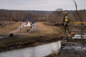 Ein ukrainischer Soldat in der Nähe einer zerstörten Brücke am Fluss Irpin.