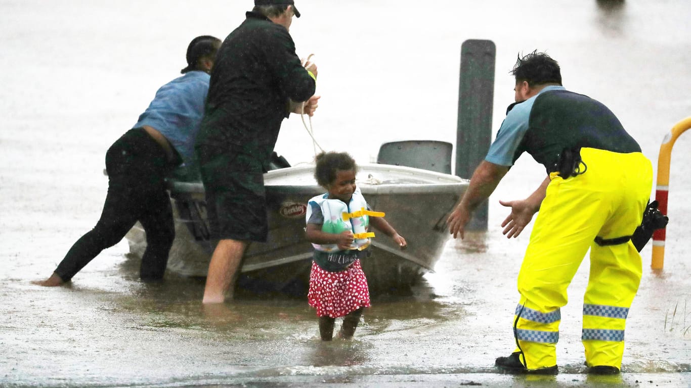 Lismore: Helfer des Katastrophenschutzes retten ein Kind aus den Fluten.