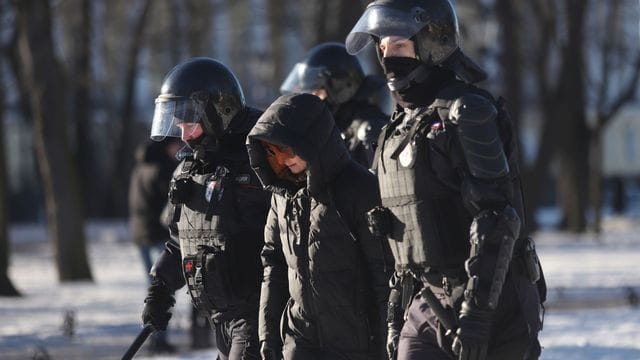 Polizeibeamte nehmen am Sonntag eine Demonstrantin in St.