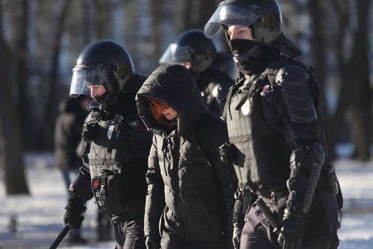 Polizeibeamte nehmen am Sonntag eine Demonstrantin in St.