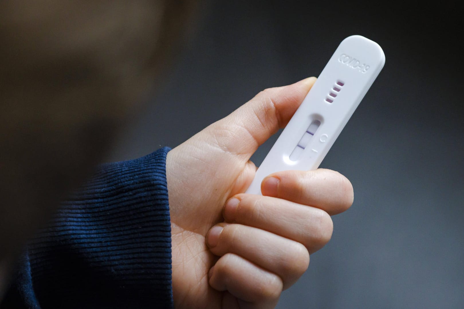 Ein Kind hält einen positiven Corona-Test in der Hand (Symbolbild): Einen Großteil der bestellten Tests lieferte das Land an Schulen und Kindergärten.