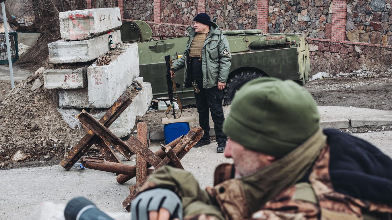 Männer bewachen einen ukrainischen Kontrollpunkt an einer Straße: Russland hat offenbar den Heimvorteil der ukrainischen Streitkräfte unterschätzt.