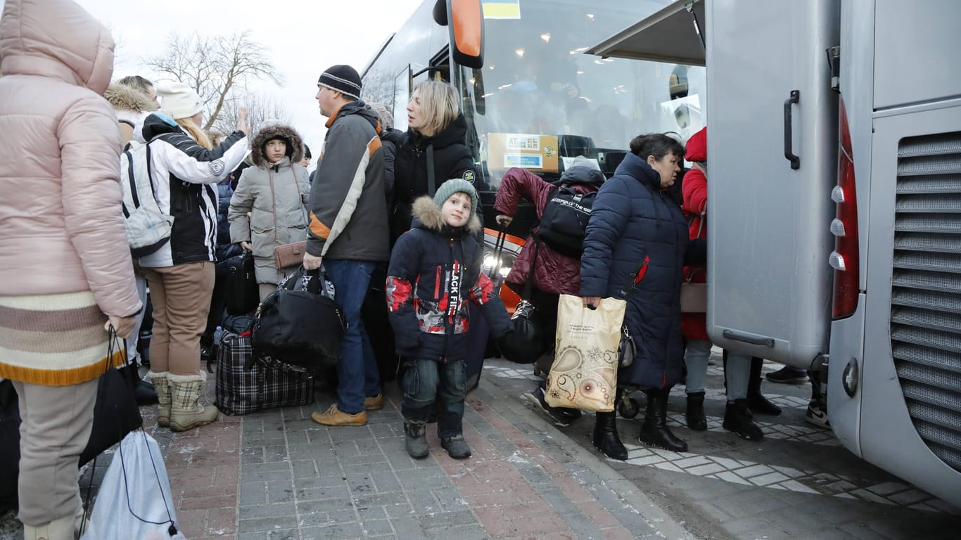Ukraine-Flüchtlinge stehen vor Reisebussen (Archivbild): Die DB stellt täglich bis zu 300 Busse zur Beförderung von Geflüchteten bereit.
