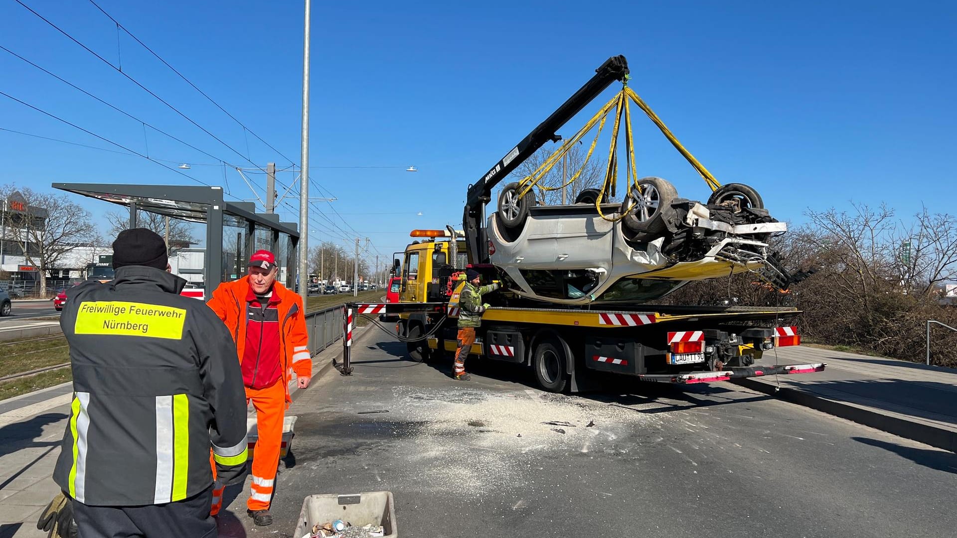 Nach einem Unfall in Nürnberg wird ein Auto abtransportiert. Zuvor hatte sich das Fahrzeug an einer Bushaltestelle überschlagen.