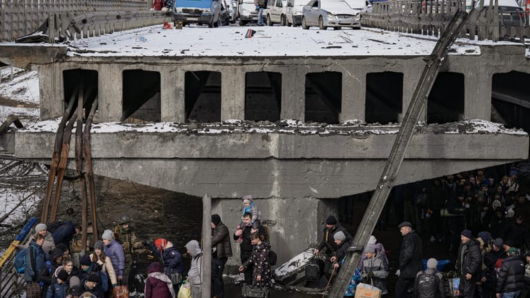 Ukraine-Verlassene Fahrzeuge von Geflüchteten stehen auf einer zerstörten Brücke, während Menschen die Stadt Irpin verlassen