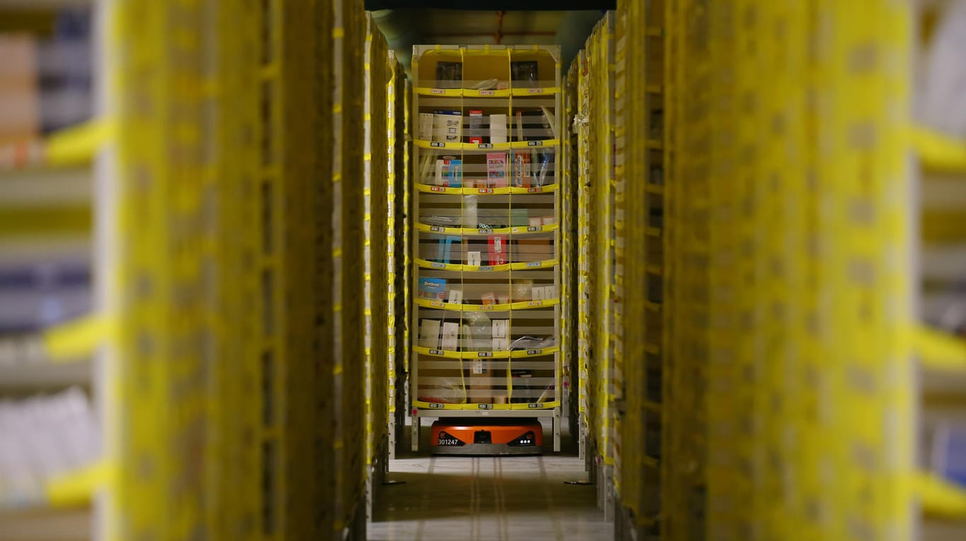 A robotic platform carries a rack by a storage area at Amazon distribution center in El Prat de Llobregat