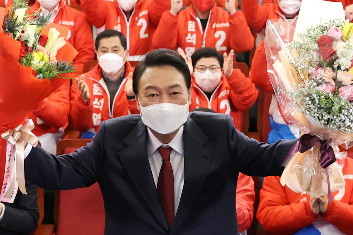 Yoon Suk Yeol: Der 61-Jährige posiert mit Blumensträußen vor der Nationalversammlung, nachdem er die Präsidentenwahl gewonnen hat.