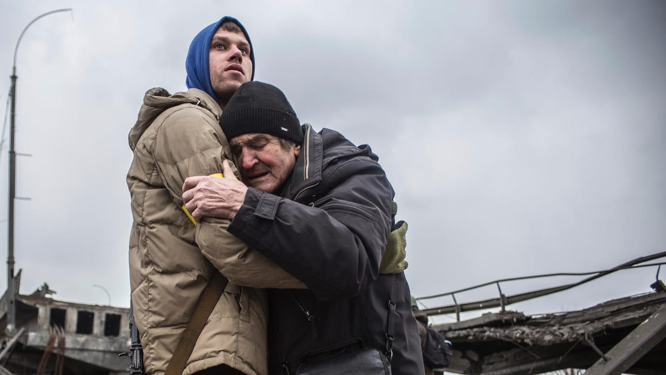 Irpin in der Nähe von Kiew: Ein Angehöriger der ukrainischen Territorialen Verteidigungskräfte umarmt einen Bewohner, der seine Heimatstadt nach russischem Artilleriebeschuss verlässt.