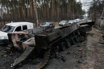 Autos fahren an einem zerstörten russischen Panzer in der Nähe von Irpin am Stadtrand von Kiew vorbei.