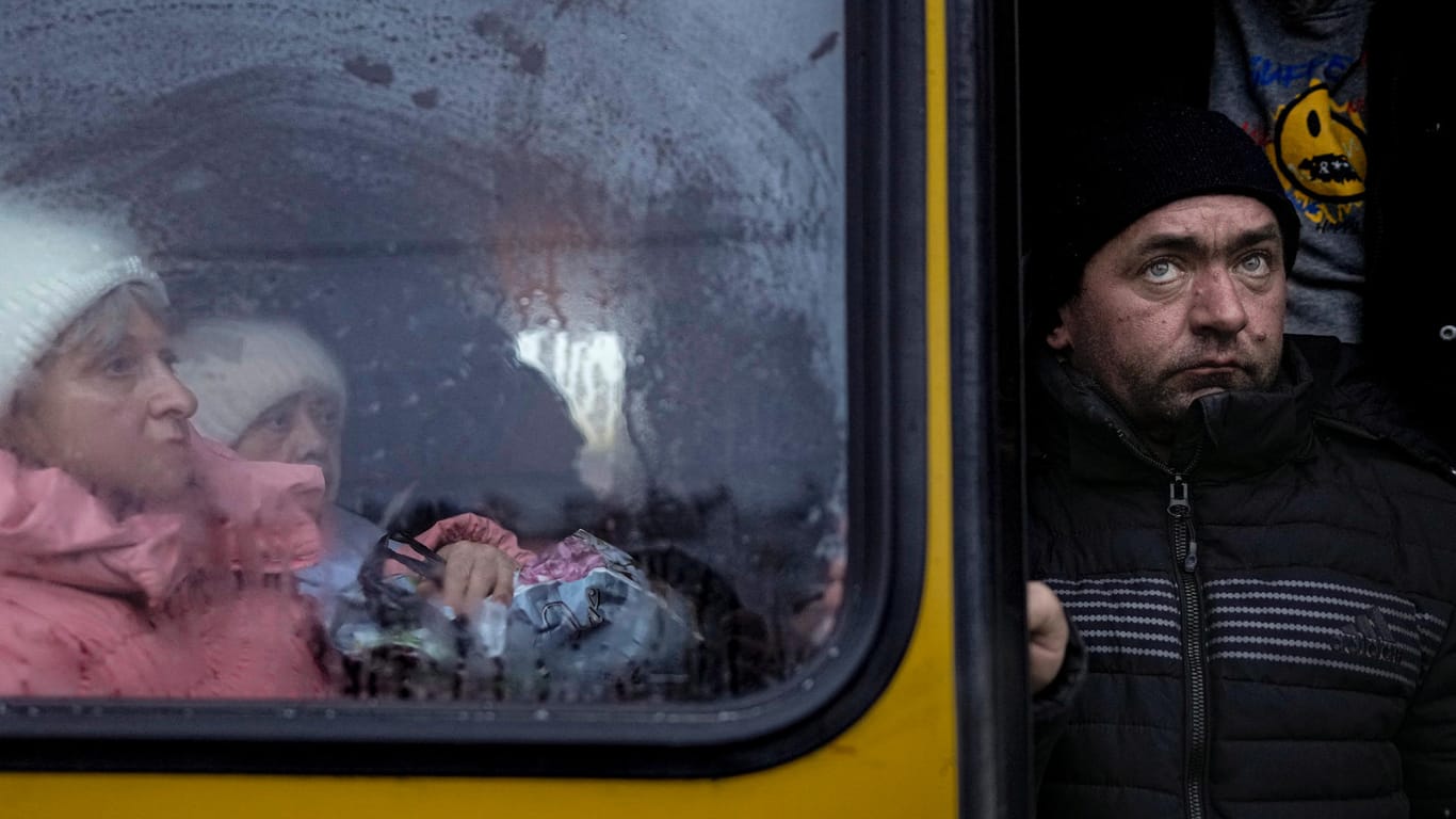 Ukraine, Kiew: Menschen, die aus Gebieten rund um die ukrainische Hauptstadt evakuiert wurden, warten auf einen Bus, nachdem sie an einem Verteilungspunkt in Kiew angekommen sind.