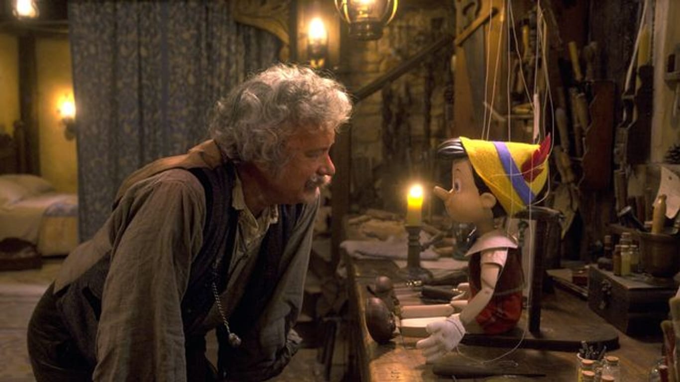 Tom Hanks (l) als Holzschnitzer Geppetto beugt sich zum computeranimierten Pinocchio herunter.