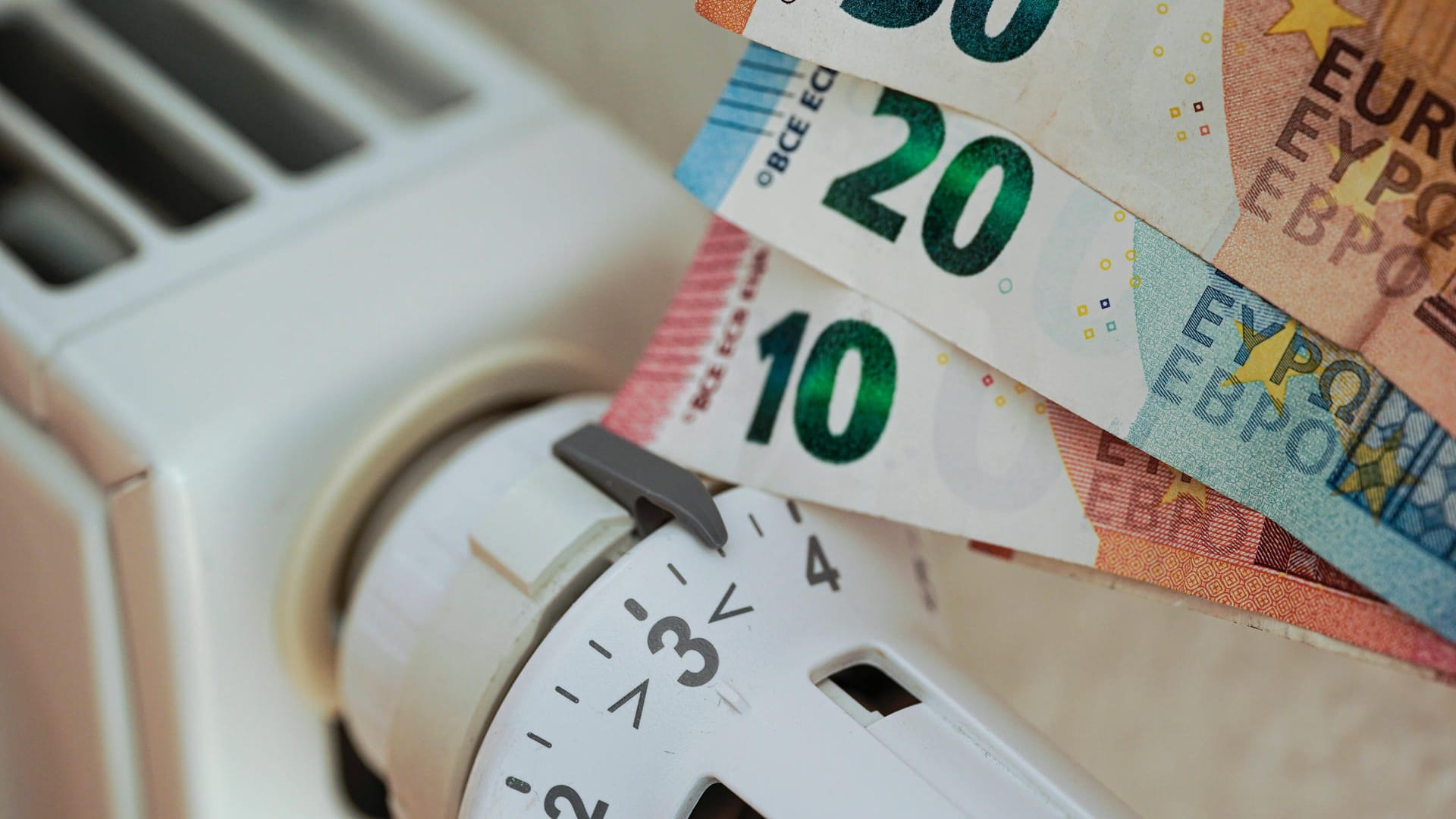 Bargeld neben einer aufgedrehten Heizung (Symbolbild): Die hohen Heizkosten stellen eine finanzielle Belastung dar. Bargeld neben einer aufgedrehten Heizung (Symbolbild): Die hohen Heizkosten stellen eine finanzielle Belastung dar.